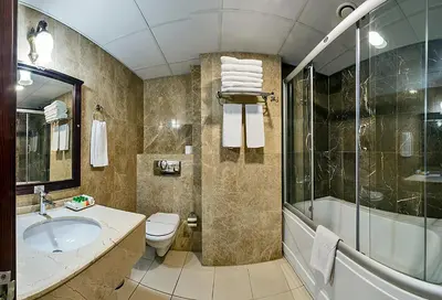 a bathroom with a sink and a tub and a toilet at Gülhanepark Hotel & Spa in Istanbul