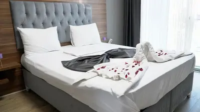 a bed with white sheets and red flowers on it at Skyport Istanbul in Istanbul