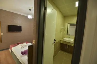 a bathroom with a bed and a sink and a mirror at Omega Luxx Hotel in Istanbul