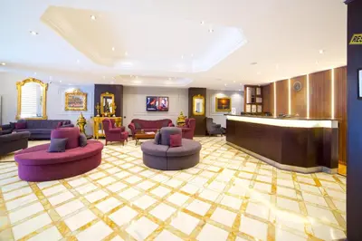a hotel lobby with purple chairs and a bar at Grand Ant Hotel in Istanbul
