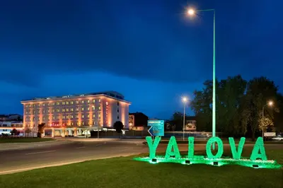 a sign in the grass in front of a building at Ramada by Wyndham Yalova in Yalova