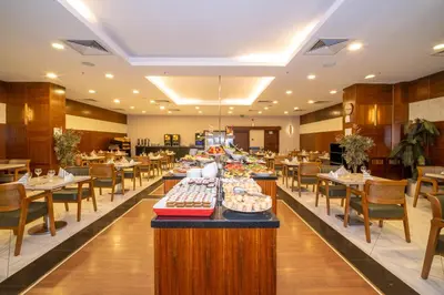 a restaurant with tables and chairs with food on display at Grand S Hotel in Istanbul