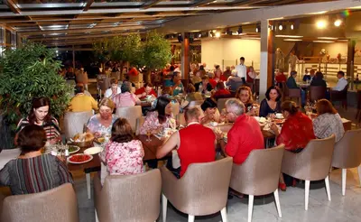 a group of people sitting at tables in a restaurant at Darkhill Hotel in Istanbul