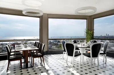 a dining room with tables and chairs and large windows at Darkhill Hotel in Istanbul