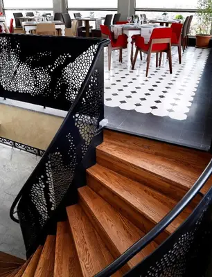a staircase in a restaurant with wooden floors and red chairs at Darkhill Hotel in Istanbul