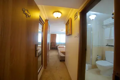 a hallway of a bathroom with a toilet and a sink at Grand Unal Hotel in Istanbul
