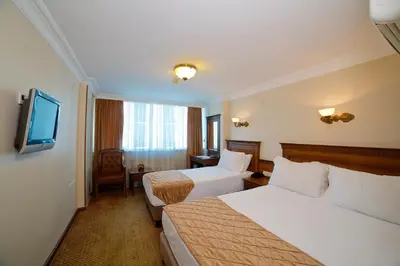 a hotel room with two beds and a television at Grand Unal Hotel in Istanbul
