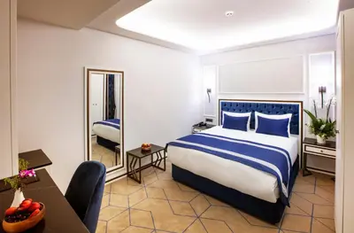 a hotel room with a bed and a desk and a mirror at Endican Beyazit Hotel in Istanbul