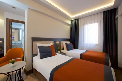 a hotel room with two beds and a table at Hotel Eyfel in Istanbul