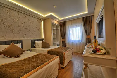a hotel room with two beds and a table at Samir Deluxe Hotel in Istanbul