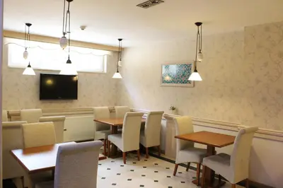 a dining room with tables and chairs and a tv at Hotel Novano in Istanbul