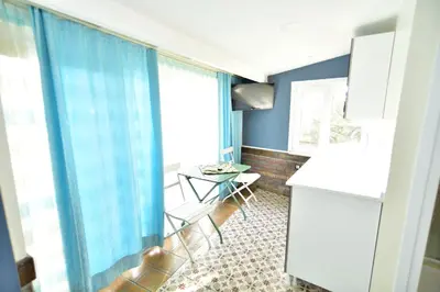 a kitchen with blue curtains and a table and chairs at Hotel Han in Istanbul