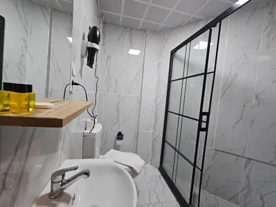 a white bathroom with a sink and a shower at Asitane Life Hotel in Istanbul
