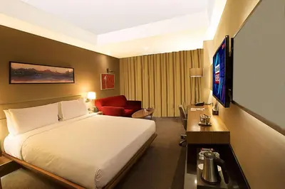 a hotel room with a bed and a red couch at DoubleTree By Hilton Istanbul - Old Town in Istanbul