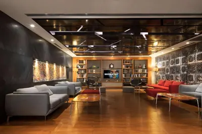 a living room with couches and red chairs at DoubleTree By Hilton Istanbul - Old Town in Istanbul