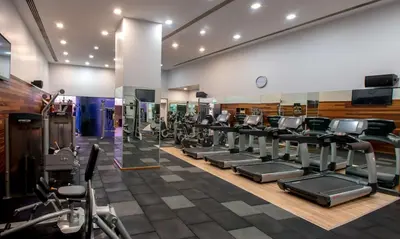 a gym with a row of treadmills and ellipticals at DoubleTree By Hilton Istanbul - Moda in Istanbul