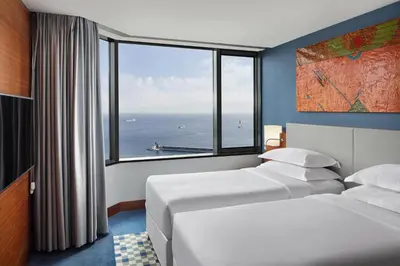 a hotel room with two beds and a large window at Sheraton Istanbul Atakoy Hotel in Istanbul