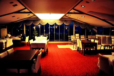 a restaurant with tables and chairs and a large window at dragos island hotel in Istanbul