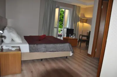 a bedroom with a bed with a red pillow on it at dragos island hotel in Istanbul