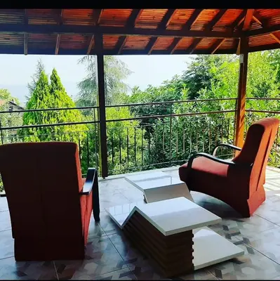 a patio with two chairs and a table and a balcony at Butik Hotel Maşukiye in Masukiye