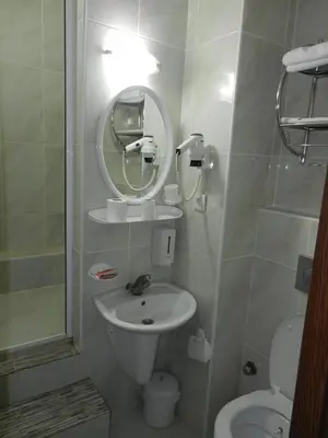 a bathroom with a sink and a mirror and a toilet at Cagri Hotel in Istanbul