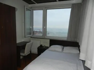 a bedroom with a bed and a large window at Cagri Hotel in Istanbul