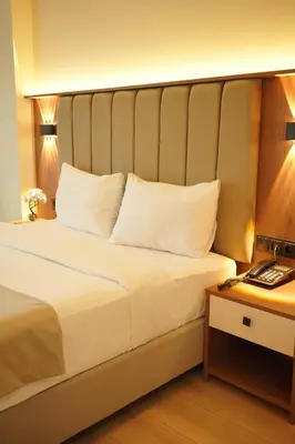 a bedroom with a large white bed with a desk at Lion City Hotel Bursa in Bursa