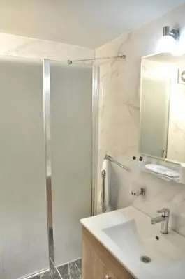 a bathroom with a shower and a sink and a mirror at Hotel Davos Istanbul in Istanbul