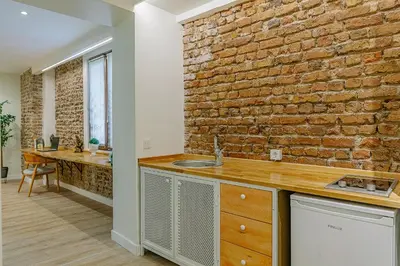 a kitchen with a brick wall and a sink at The Wilson Galata Hotel in Istanbul