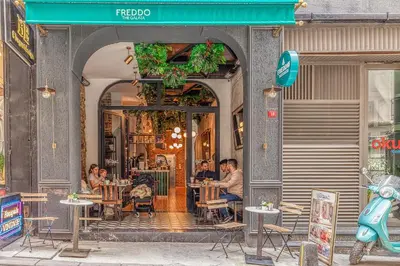 a group of people sitting at tables outside a restaurant at The Wilson Galata Hotel in Istanbul