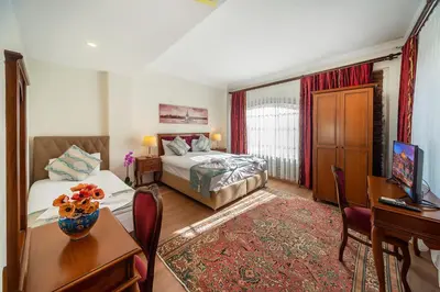 a bedroom with two beds and a desk and a television at Sultan House in Istanbul