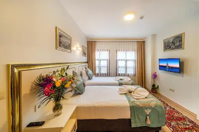 a bedroom with a large bed with a vase of flowers on it at Sultan House in Istanbul