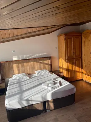 a bedroom with a large bed with a wooden ceiling at Odrys Beach Hotel & Resort in Tekirdag