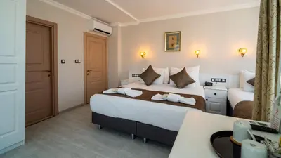 a hotel room with two beds and a desk at Sultanahmet Cesme Hotel in Istanbul
