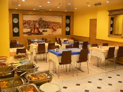 a dining room with tables and chairs with food at Hotel Inter Istanbul in Istanbul