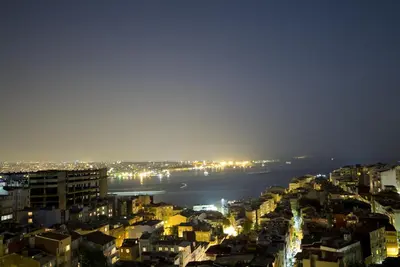 a view of a city at night with the water at Innpera Hotel in Istanbul