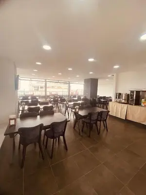 a large room with tables and chairs and a cafeteria at Malkoç Hotel in Istanbul