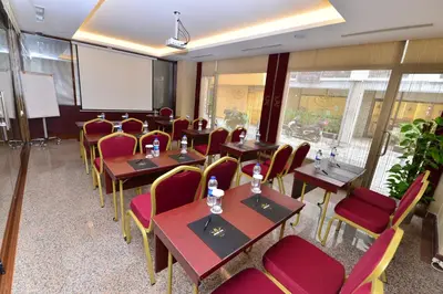 a conference room with tables and chairs and a screen at Golden Siyav Hotel in Istanbul