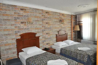 a hotel room with two beds and a brick wall at Hotel Red Rose in Istanbul