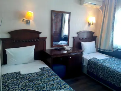 a hotel room with two beds and a mirror at Hotel Red Rose in Istanbul