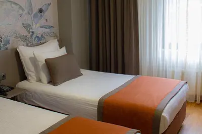 a hotel room with two beds and a window at Benler Otel Laleli ISTanbul in Istanbul