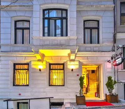a white building with a bench in front of it at Taksim Istiklal Street Next2 Hotel in Istanbul