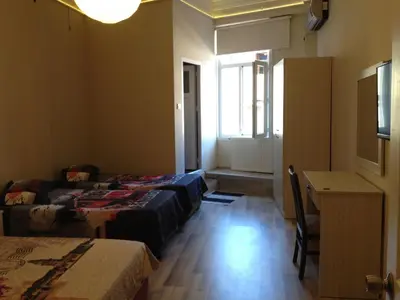 a room with two beds and a desk and a window at Erenler HoTeL & HosTeL in Istanbul