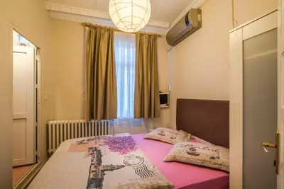 a bedroom with a bed with pink sheets and a window at Erenler HoTeL & HosTeL in Istanbul