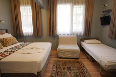 a hotel room with two beds and a chair at Topkapi Apartments in Istanbul
