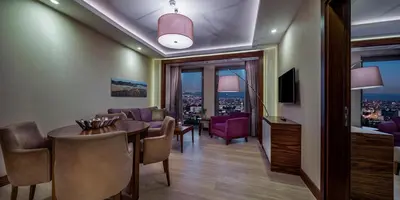 a room with a dining table and a living room at Doubletree By Hilton Istanbul Topkapi in Istanbul