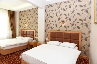 two beds in a hotel room with wallpaper at Hotel Grand Umit in Istanbul
