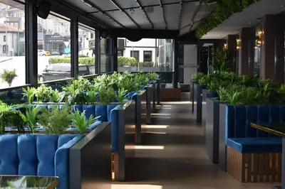 a row of plants in a restaurant with blue seats at Hotel Anatolia in Bursa