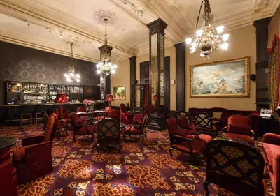 a room with chairs and a bar in a building at Pera Palace Hotel in Istanbul