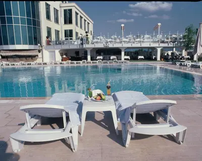 a table and chairs next to a swimming pool at EmexOtel Kocaeli in Kocaeli